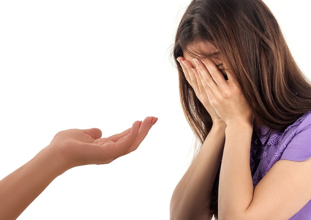 main tendue vers une femme triste qui se tient le visage avec ses mains dépression thérapie