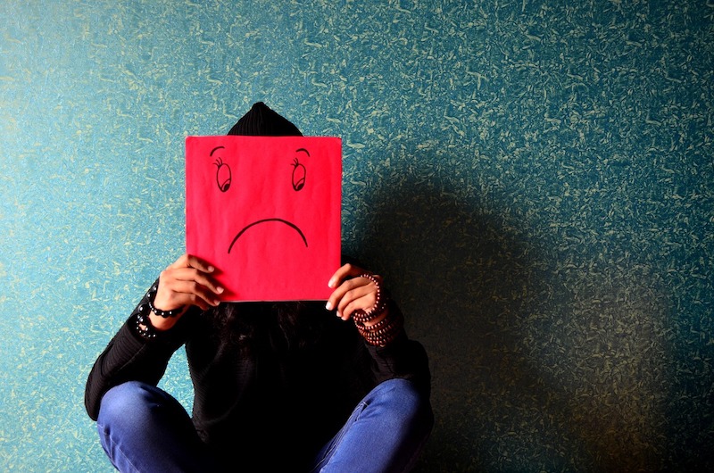 homme avec un dessin de tête triste devant son visage dépression thérapie
