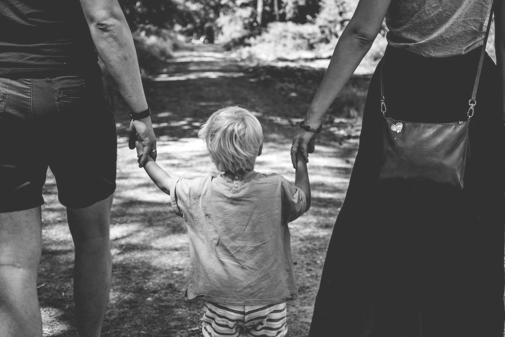 couple parents marchant de dos et tenant la main de leur enfant thérapie